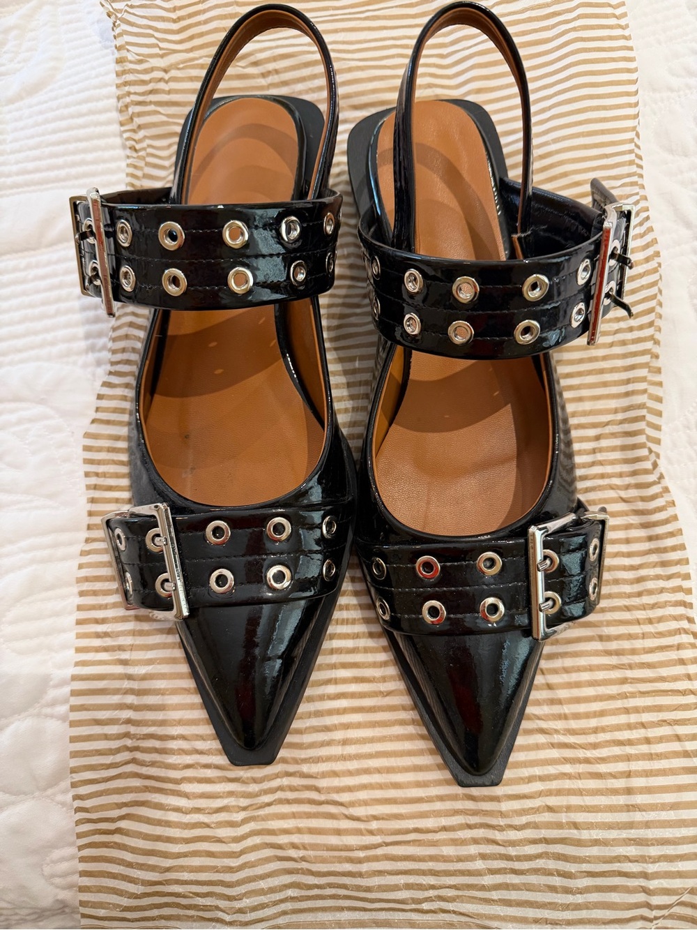 Black Patent Pointed Slingback Flats with Buckle and Grommet Straps.